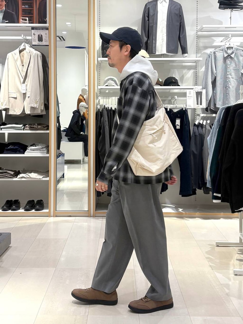 ブラウン系のスニーカー、グレー系のその他パンツ、ホワイト系のショルダーバッグを着用したメンズの春コーディネートの2枚目の写真