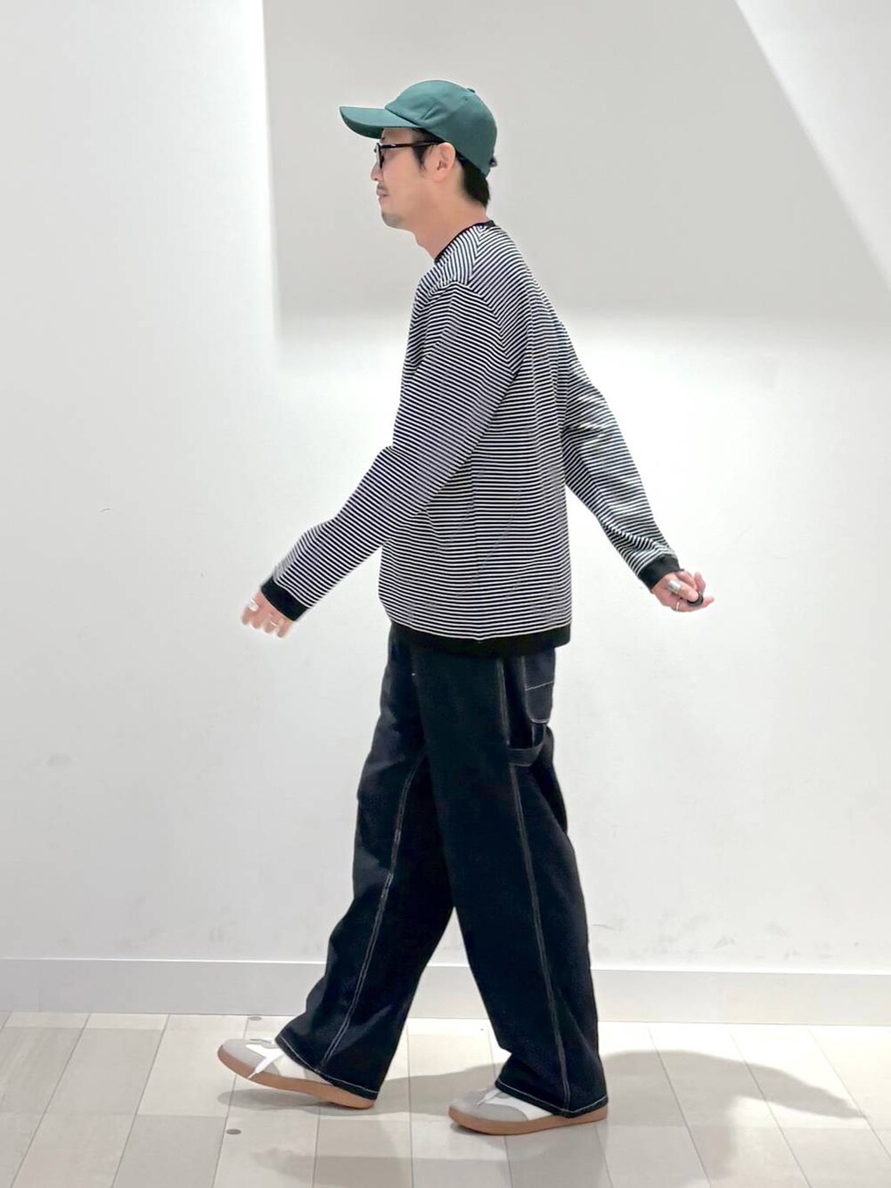 ベージュ系のスニーカー、ブルー系のデニムパンツ、ブラック系のスウェットを着用したメンズの秋コーディネートの2枚目の写真