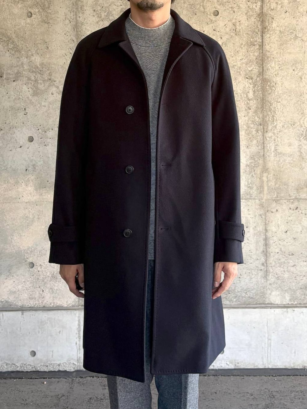 ブルー系のステンカラーコート、グレー系のスラックス、グレー系のニット/セーターを着用したメンズの秋コーディネートの2枚目の写真