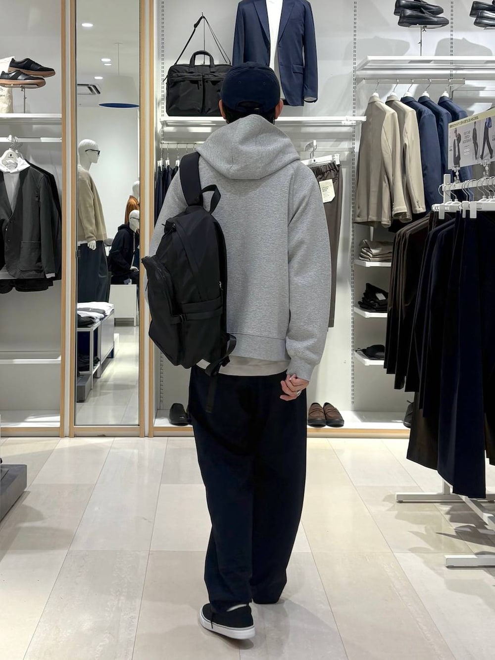 ブラック系のバックパック/リュック、ベージュ系のTシャツ/カットソー、グレー系のパーカーを着用したメンズの春コーディネートの3枚目の写真