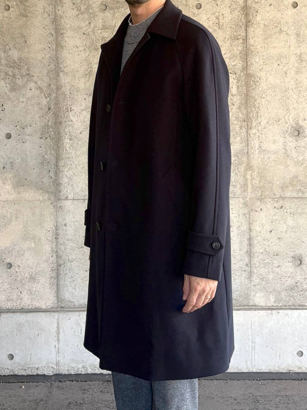 ブルー系のステンカラーコート、グレー系のスラックス、グレー系のニット/セーターを着用したメンズの秋コーディネートの3枚目の写真