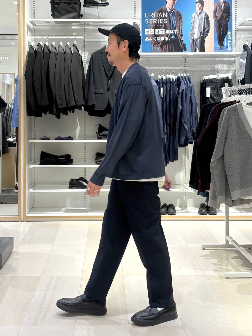 ホワイト系のTシャツ/カットソー、ブルー系のスラックス、グレー系のその他シューズを着用したメンズの秋コーディネートの2枚目の写真
