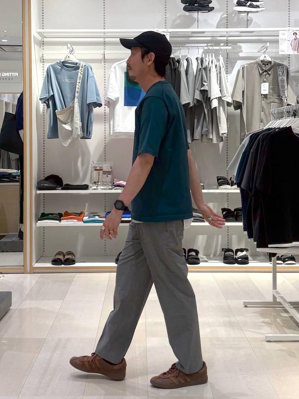 グレー系のスラックス、グリーン系のTシャツ/カットソーを着用したメンズの夏コーディネートの2枚目の写真
