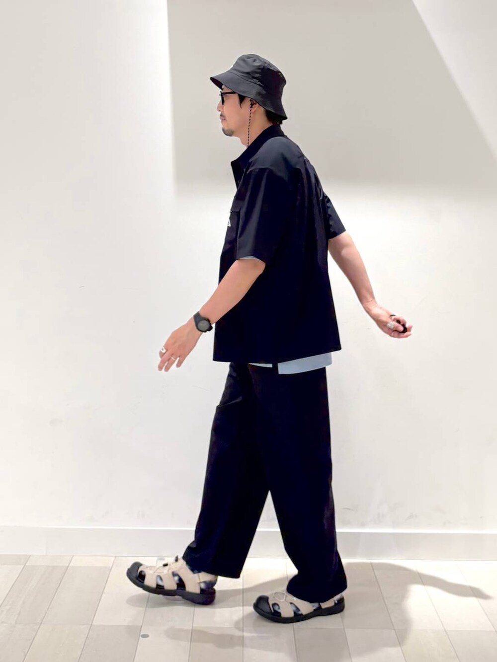 ブルー系のTシャツ/カットソー、ベージュ系のサンダル、ブルー系のその他パンツを着用したメンズの夏コーディネートの2枚目の写真