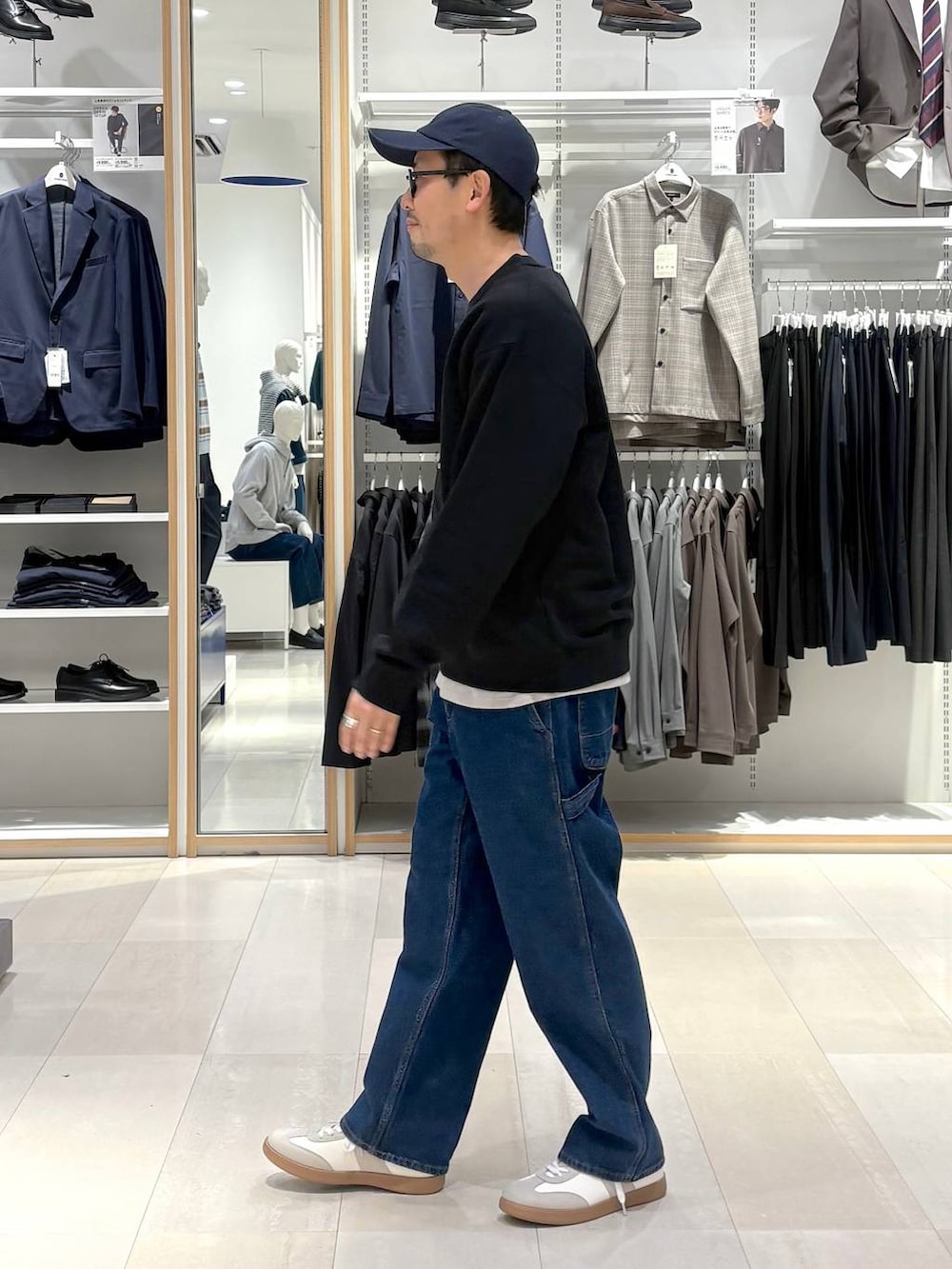 ベージュ系のスニーカー、ブラック系のスウェット、ブルー系のデニムパンツを着用したメンズの冬コーディネートの2枚目の写真