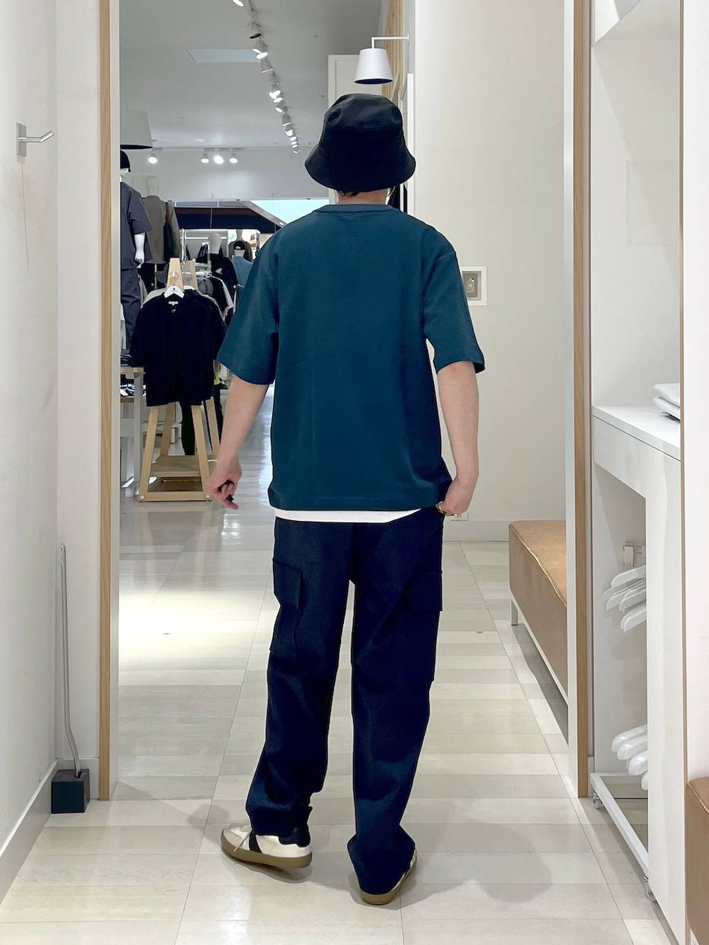 ホワイト系のスニーカー、ブルー系のカーゴパンツ、ベージュ系のスウェットを着用したメンズの夏コーディネートの3枚目の写真