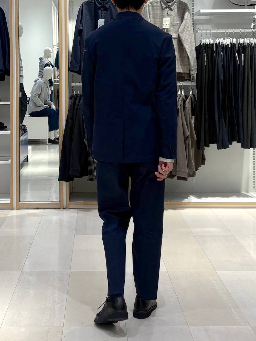 ブルー系のデニムジャケット、ブルー系のスラックス、グレー系のニット/セーターを着用したメンズの春コーディネートの3枚目の写真