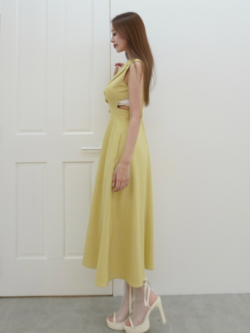 ホワイト系のサンダル、イエロー系のワンピースを着用したレディースの春コーディネートの2枚目の写真