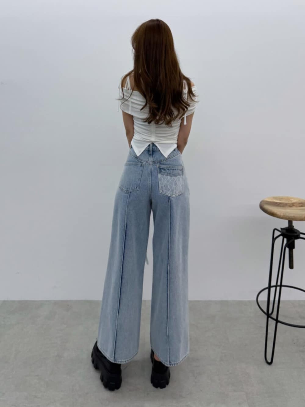 ブルー系のデニムパンツ、ホワイト系のTシャツ/カットソー、ブラック系のサンダルを着用したレディースの春コーディネートの3枚目の写真