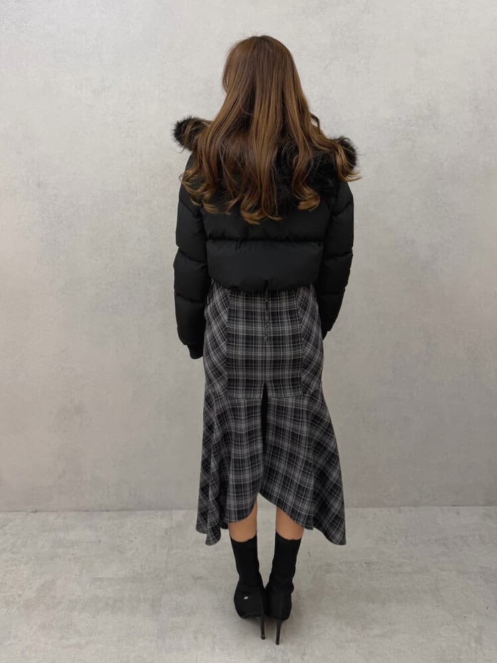 ブラック系のブーツ、ブラック系のブルゾン、ブラック系のワンピースを着用したレディースの冬コーディネートの3枚目の写真