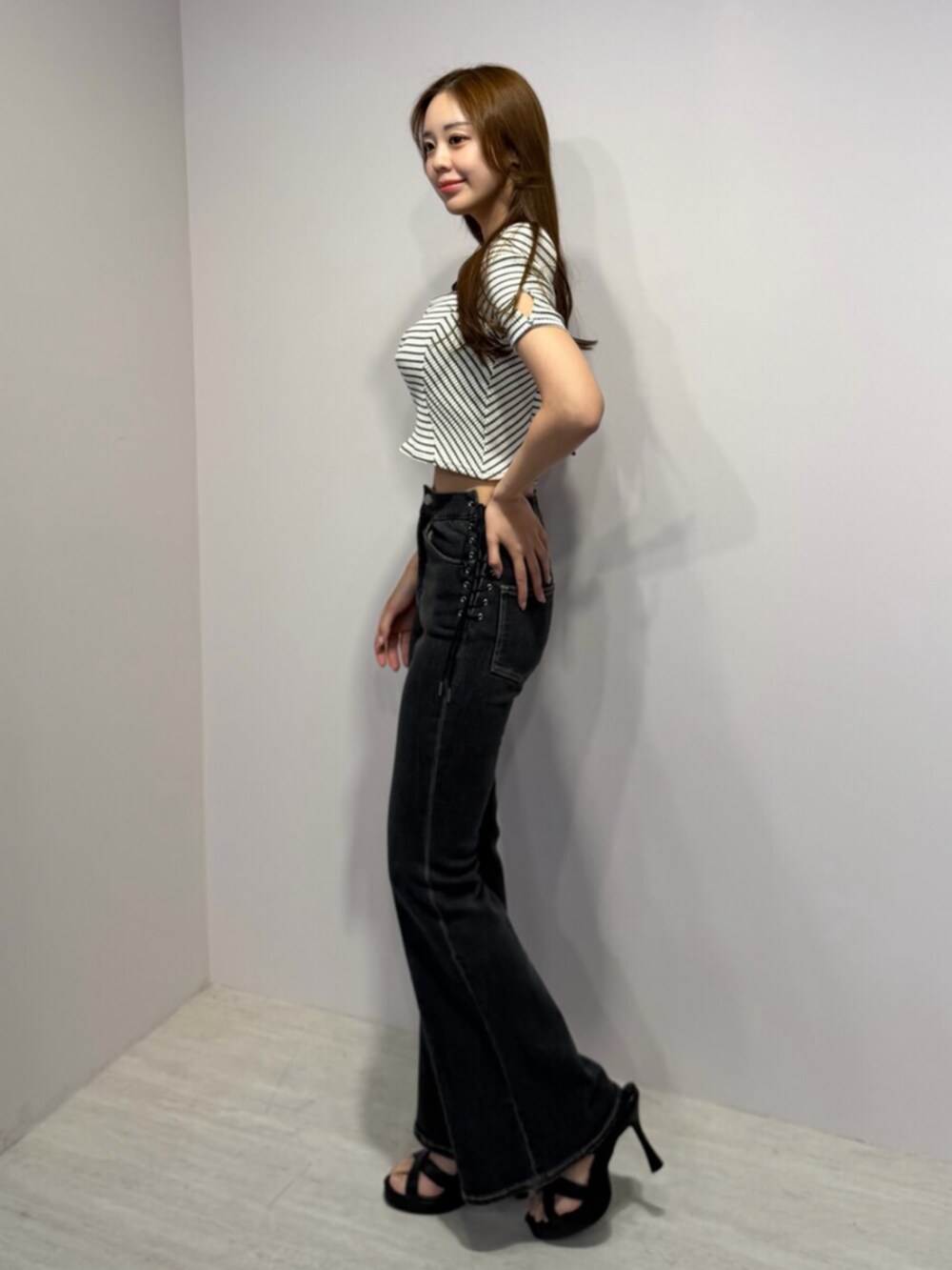 ブラック系のサンダル、その他のTシャツ/カットソー、ブラック系のデニムパンツを着用したレディースの春コーディネートの2枚目の写真
