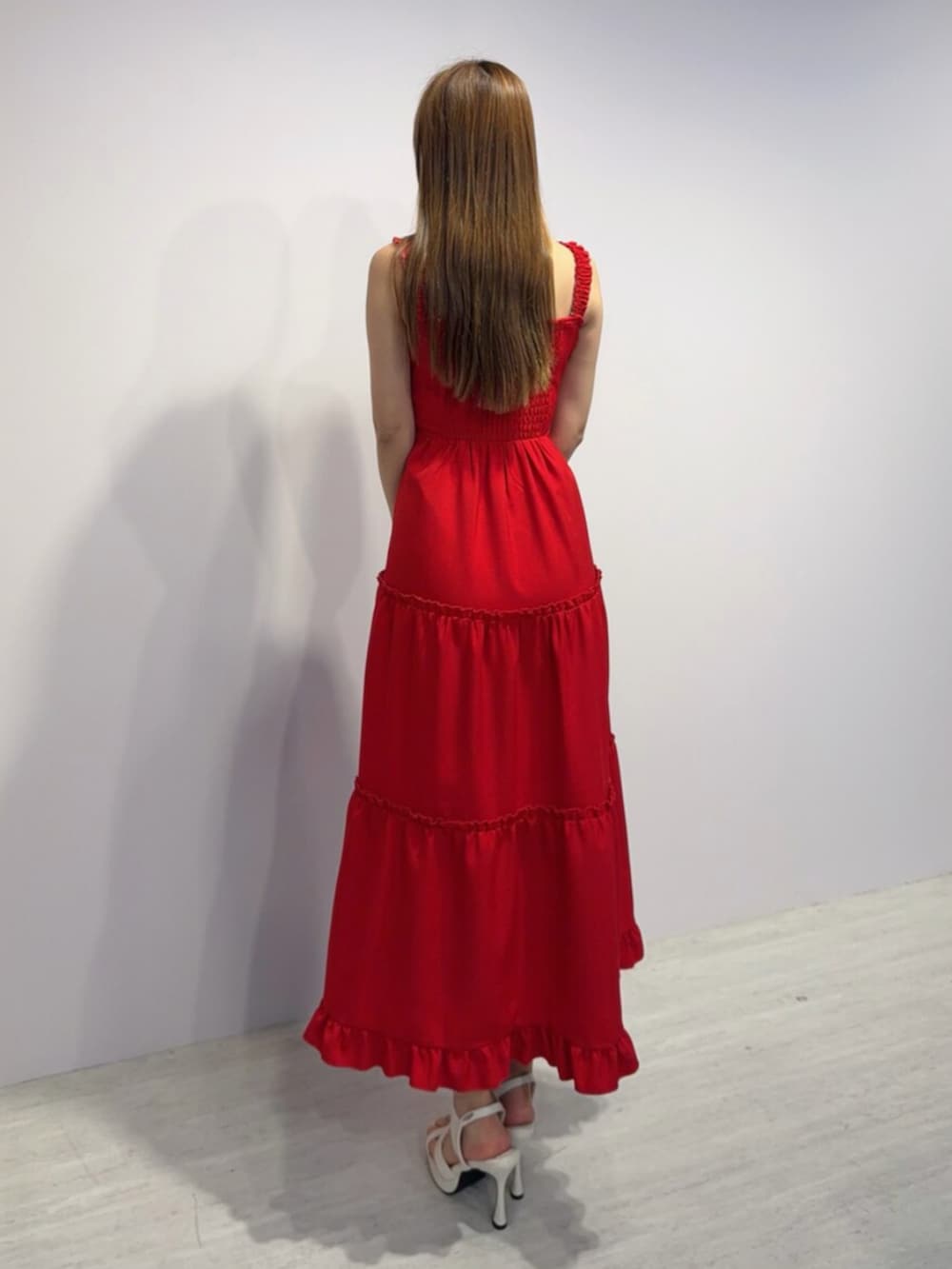 レッド系のワンピース、ホワイト系のサンダルを着用したレディースの春コーディネートの3枚目の写真