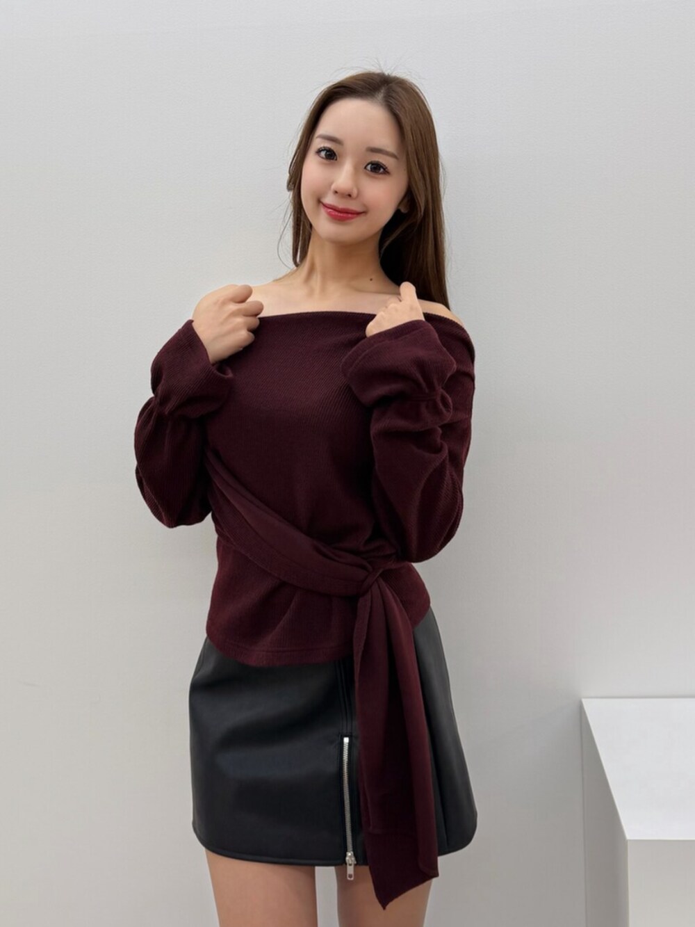 ブラック系のブーツ、ブラック系のスカート、レッド系のTシャツ/カットソーを着用したレディースの冬コーディネートの2枚目の写真