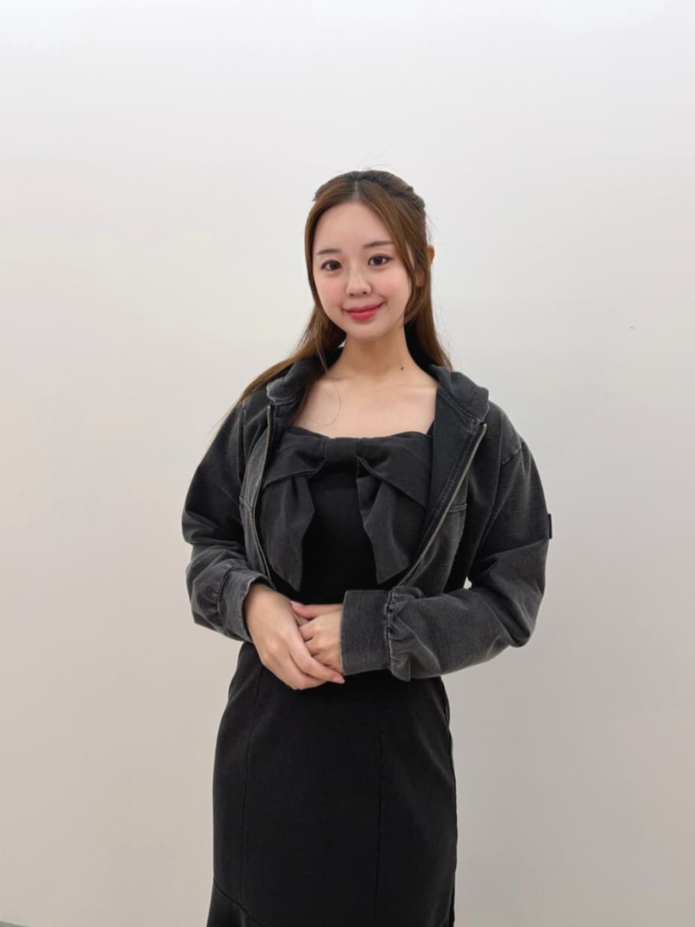 ブラック系のワンピース、ブラック系のパーカー、ホワイト系のブーツを着用したレディースの春コーディネートの4枚目の写真