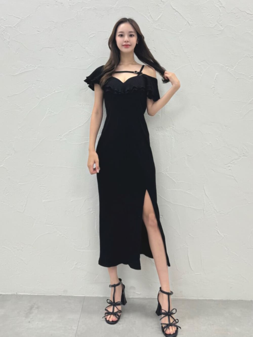 ホワイト系のサンダル、ブラック系のワンピースを着用したレディースの夏コーディネートの2枚目の写真