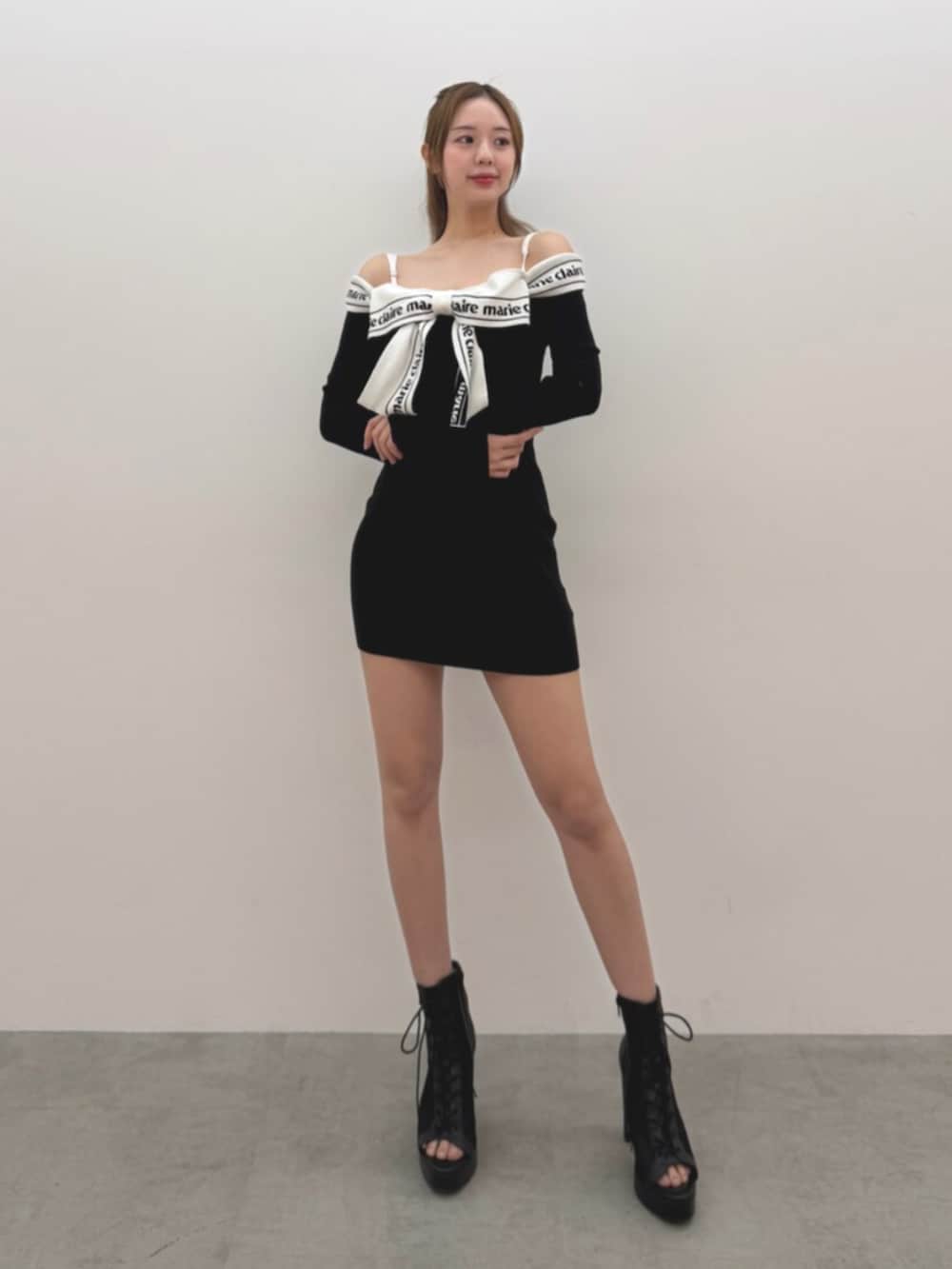 ブラック系のワンピース、ブラック系のブーツを着用したレディースの冬コーディネートの2枚目の写真