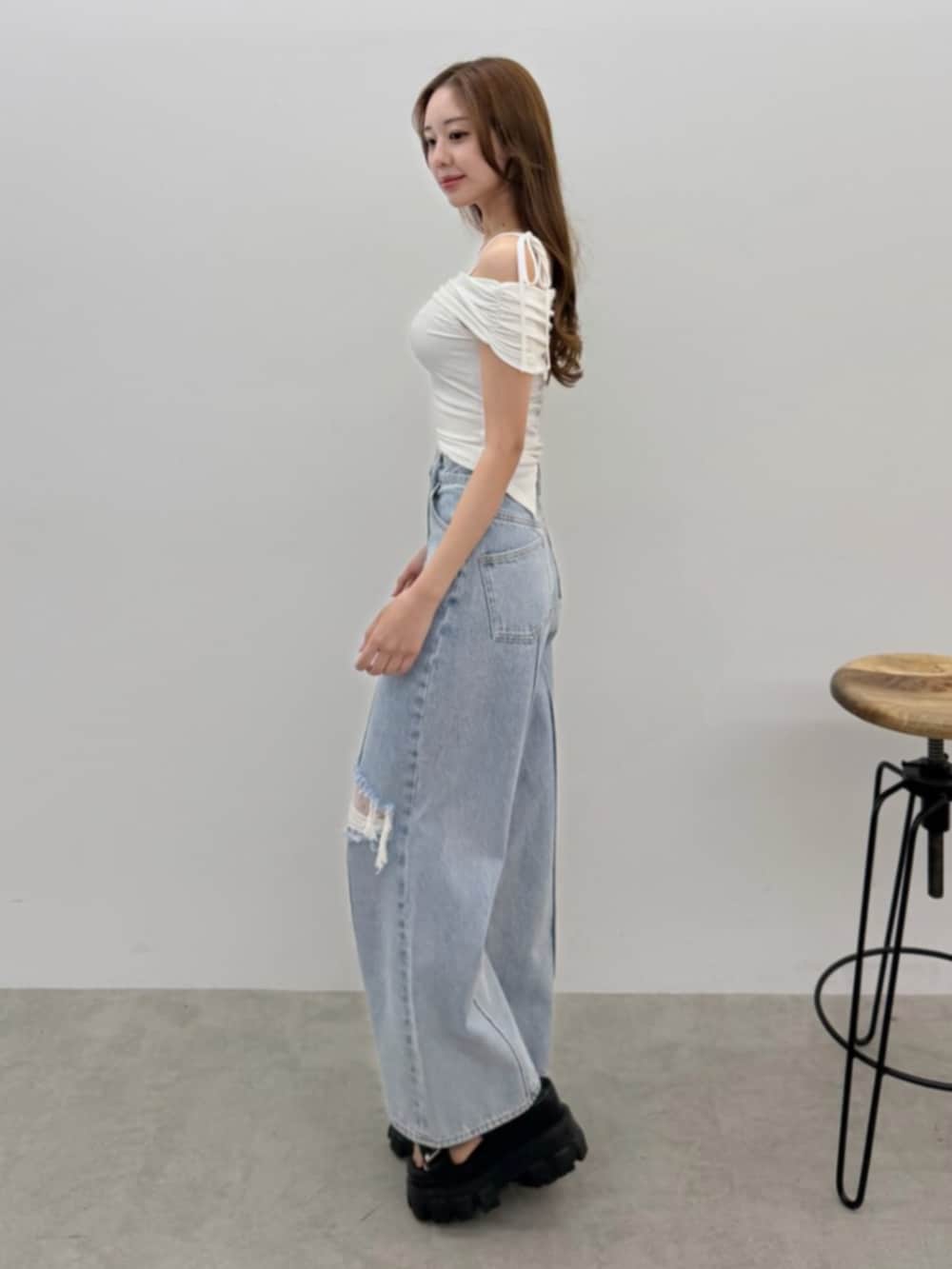 ブルー系のデニムパンツ、ホワイト系のTシャツ/カットソー、ブラック系のサンダルを着用したレディースの春コーディネートの2枚目の写真