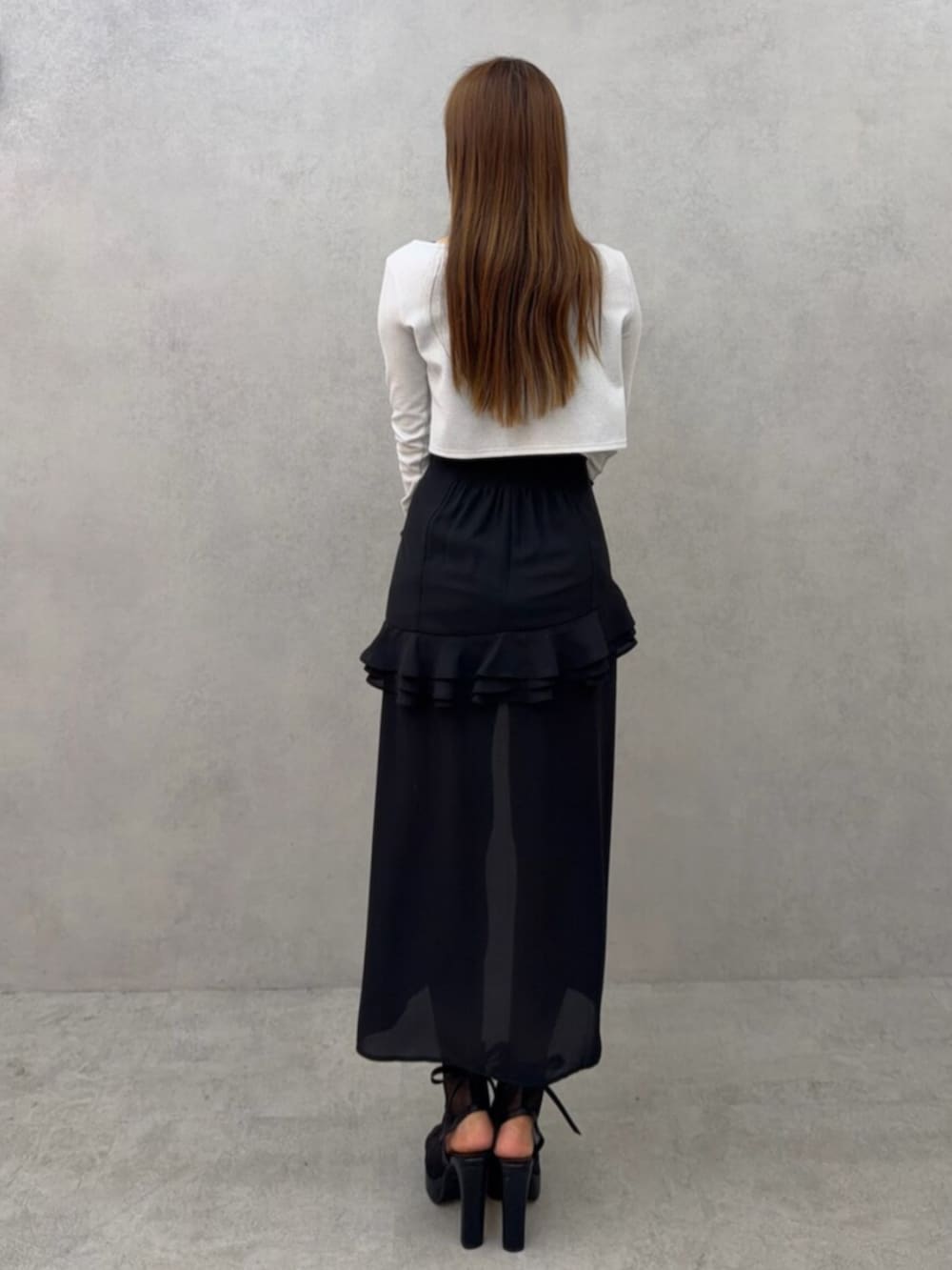 ホワイト系のブーツ、ホワイト系のカーディガン/ボレロ、ブラック系のワンピースを着用したレディースの春コーディネートの4枚目の写真