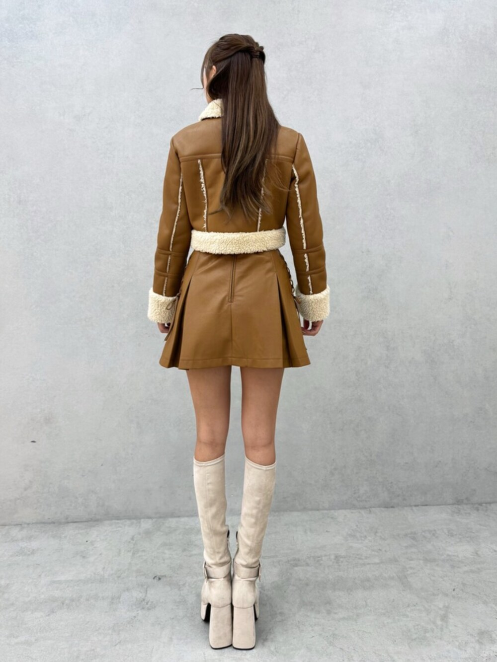 ホワイト系のブーツ、ブラウン系のスカート、ブラウン系のブルゾンを着用したレディースの秋コーディネートの3枚目の写真