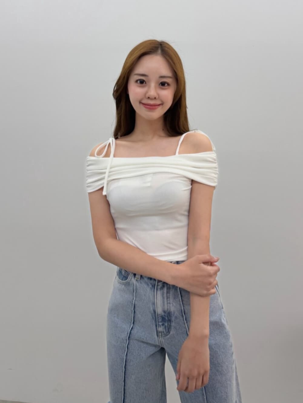 ブルー系のデニムパンツ、ホワイト系のTシャツ/カットソー、ブラック系のサンダルを着用したレディースの春コーディネートの4枚目の写真