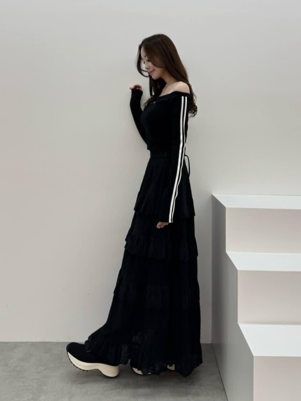 ホワイト系のブーツ、ブラック系のスカート、ブラック系のTシャツ/カットソーを着用したレディースの春コーディネートの3枚目の写真