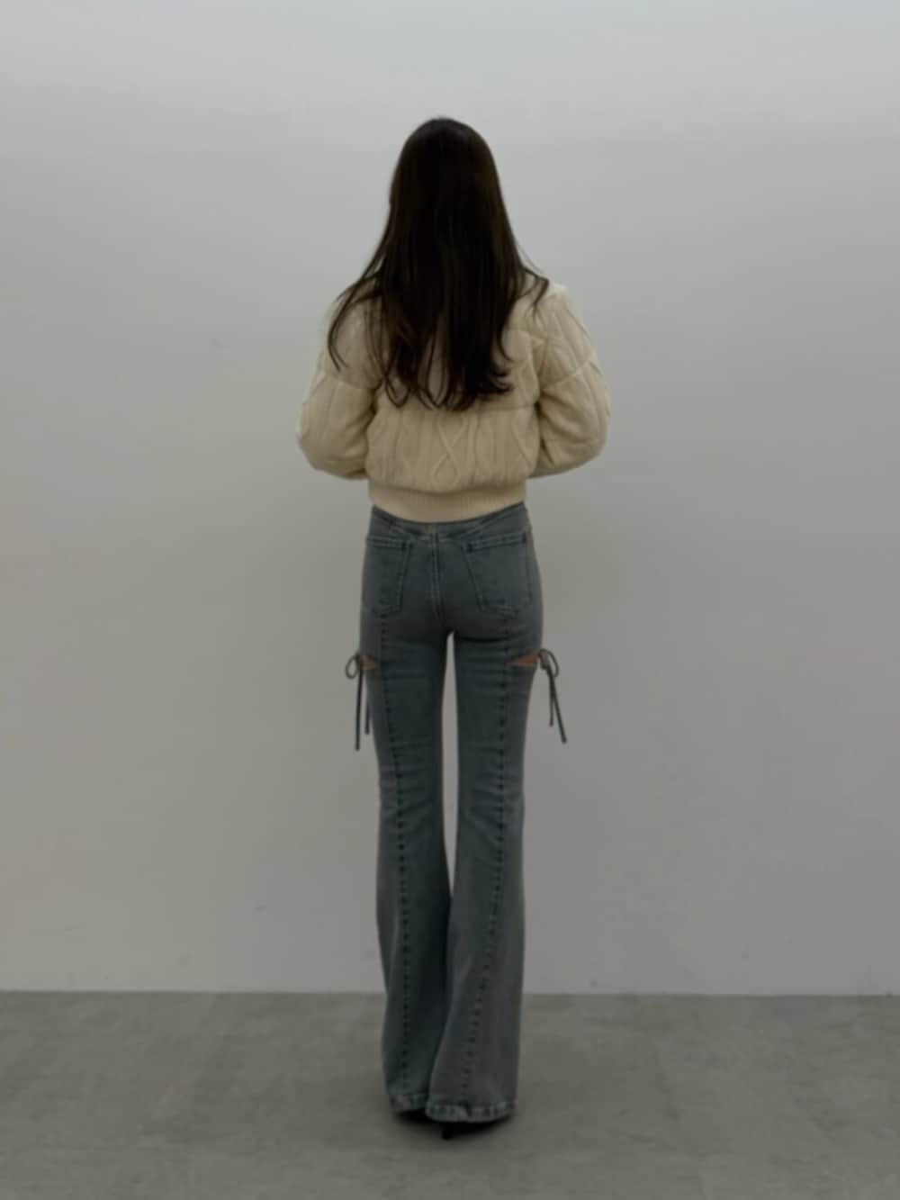 ブルー系のデニムパンツ、ブラック系のTシャツ/カットソー、ホワイト系のダウンジャケット/コートを着用したレディースの夏コーディネートの3枚目の写真