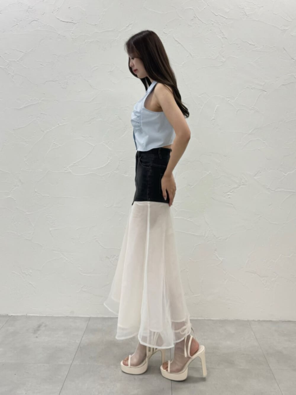 ホワイト系のサンダル、ブルー系のシャツ/ブラウス、ブラック系のデニムスカートを着用したレディースの夏コーディネートの3枚目の写真