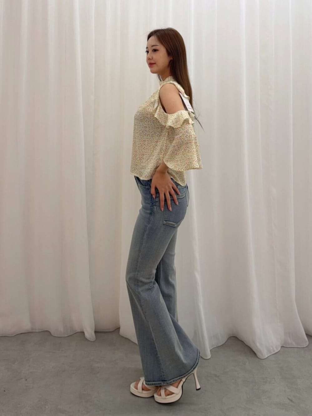 ホワイト系のサンダル、イエロー系のシャツ/ブラウス、ブルー系のデニムパンツを着用したレディースの春コーディネートの2枚目の写真