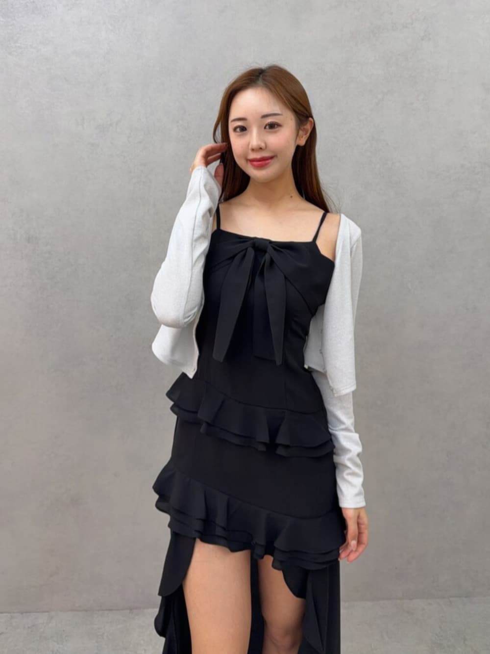 ホワイト系のブーツ、ホワイト系のカーディガン/ボレロ、ブラック系のワンピースを着用したレディースの春コーディネートの3枚目の写真