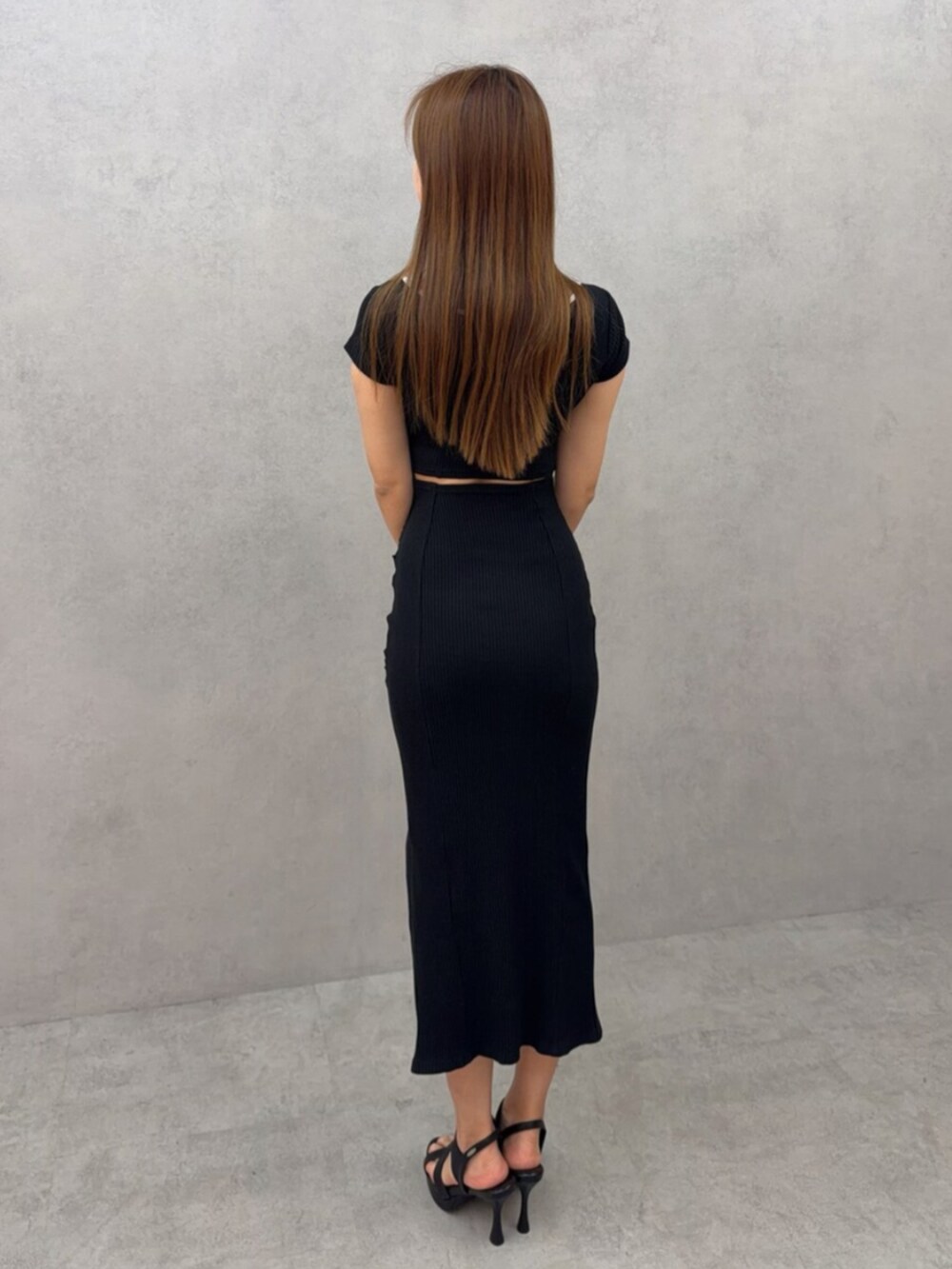 ホワイト系のサンダル、ブラック系のワンピースを着用したレディースの春コーディネートの3枚目の写真