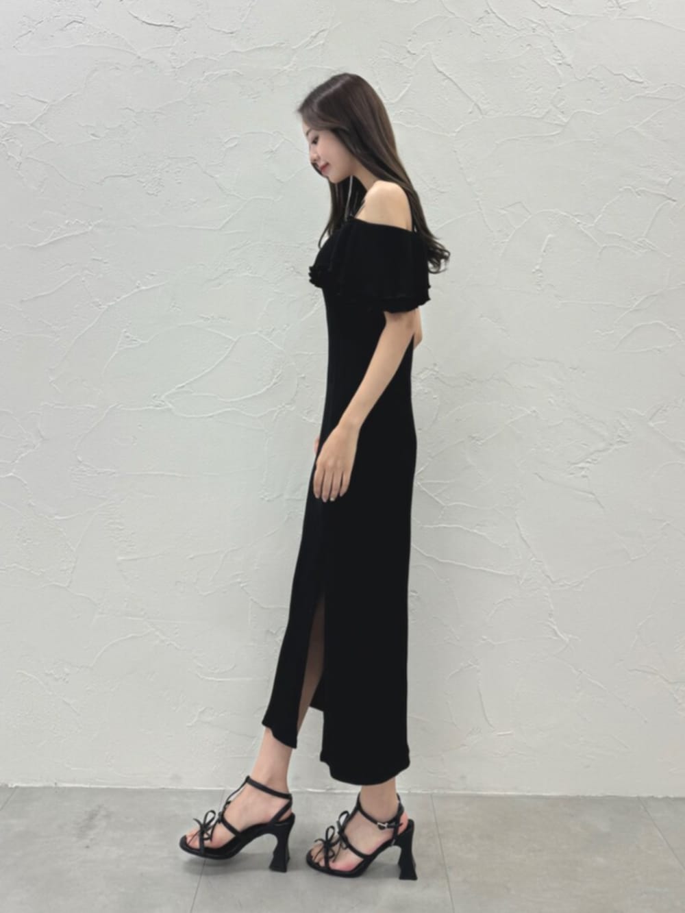 ホワイト系のサンダル、ブラック系のワンピースを着用したレディースの夏コーディネートの3枚目の写真