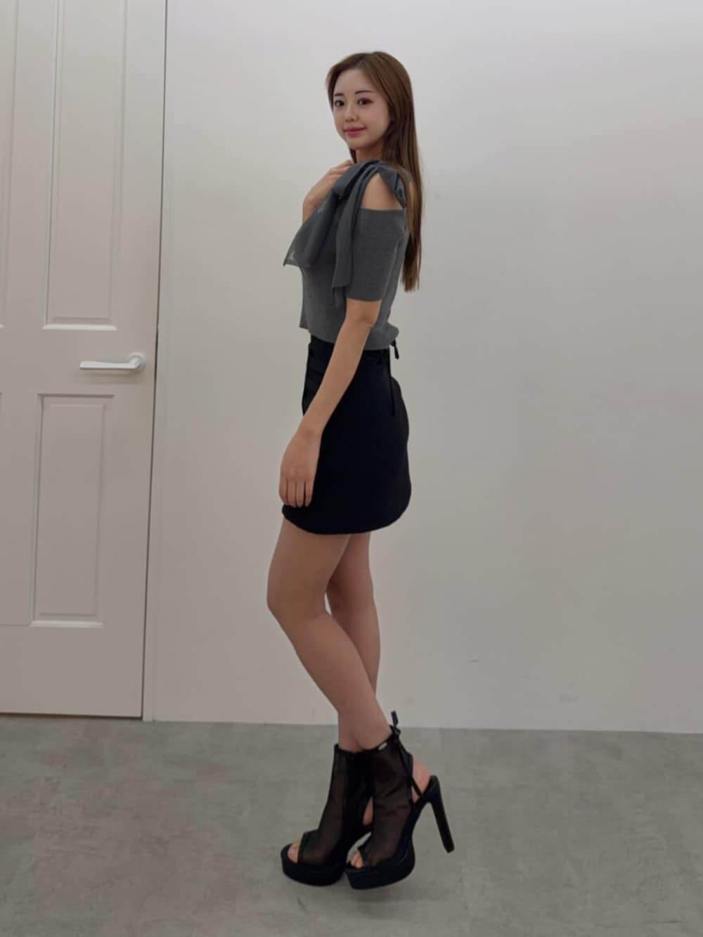 ブラック系のサンダル、グレー系のTシャツ/カットソー、ブラック系のスカートを着用したレディースの春コーディネートの2枚目の写真