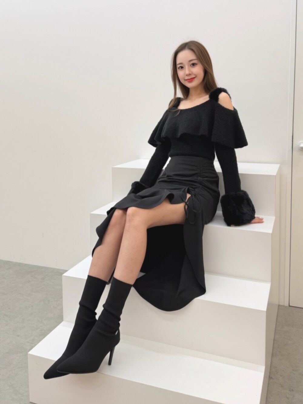 ブラック系のブーツ、ブラック系のニット/セーター、ブラック系のスカートを着用したレディースの冬コーディネートの4枚目の写真