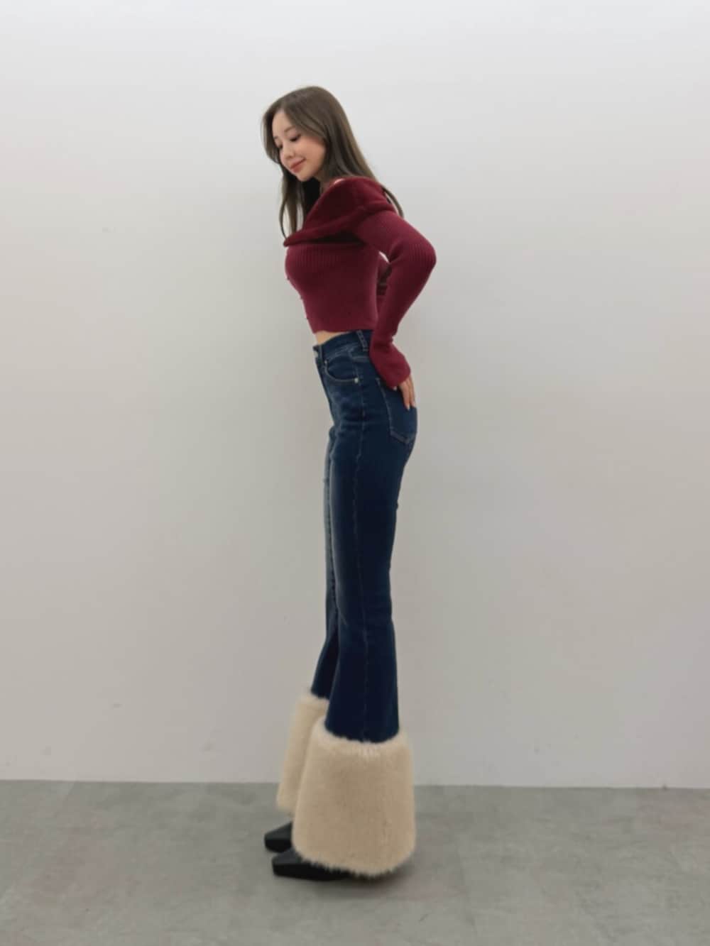 レッド系のニット/セーター、ブルー系のデニムパンツを着用したレディースの夏コーディネートの3枚目の写真