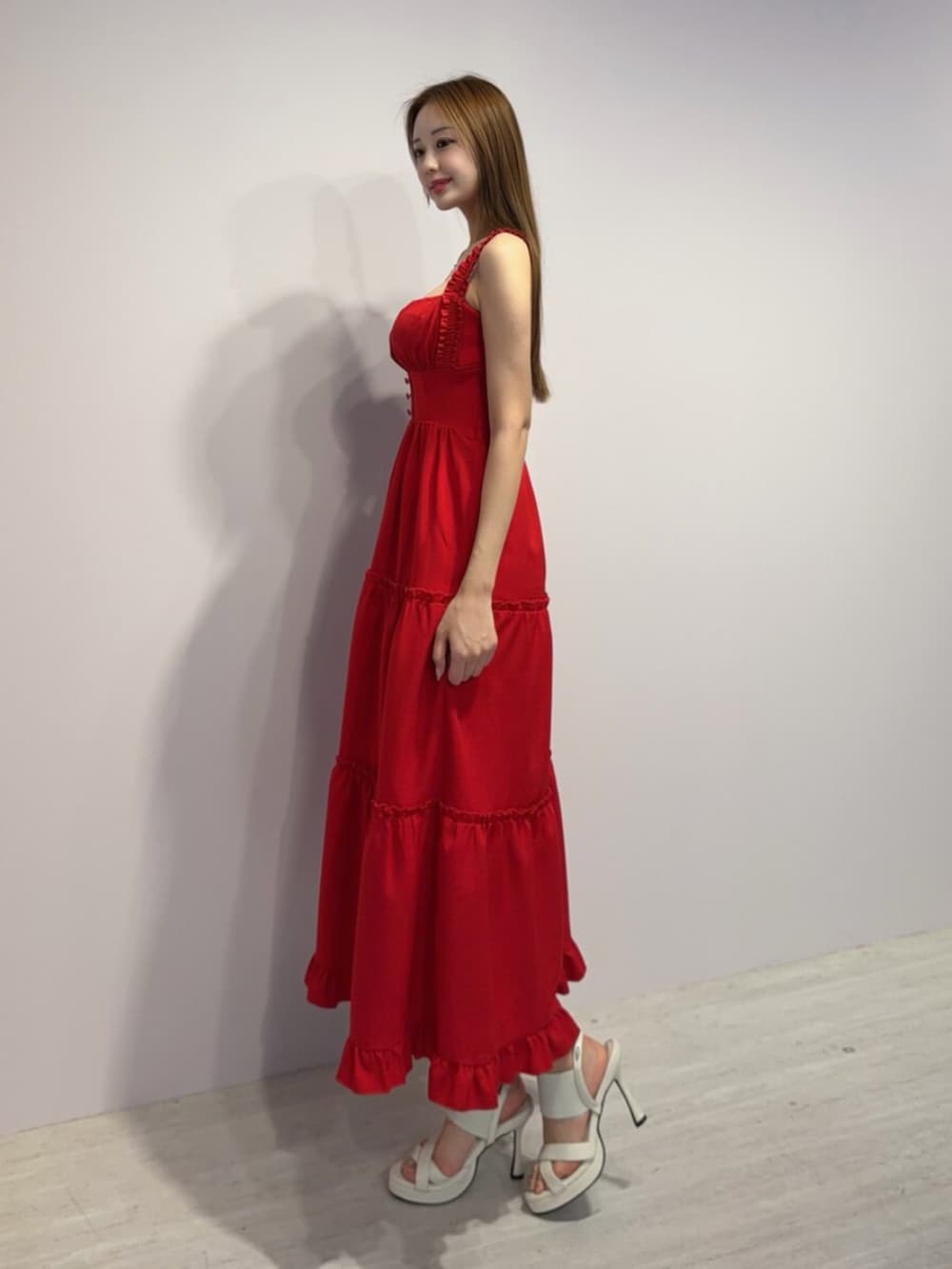 レッド系のワンピース、ホワイト系のサンダルを着用したレディースの春コーディネートの2枚目の写真