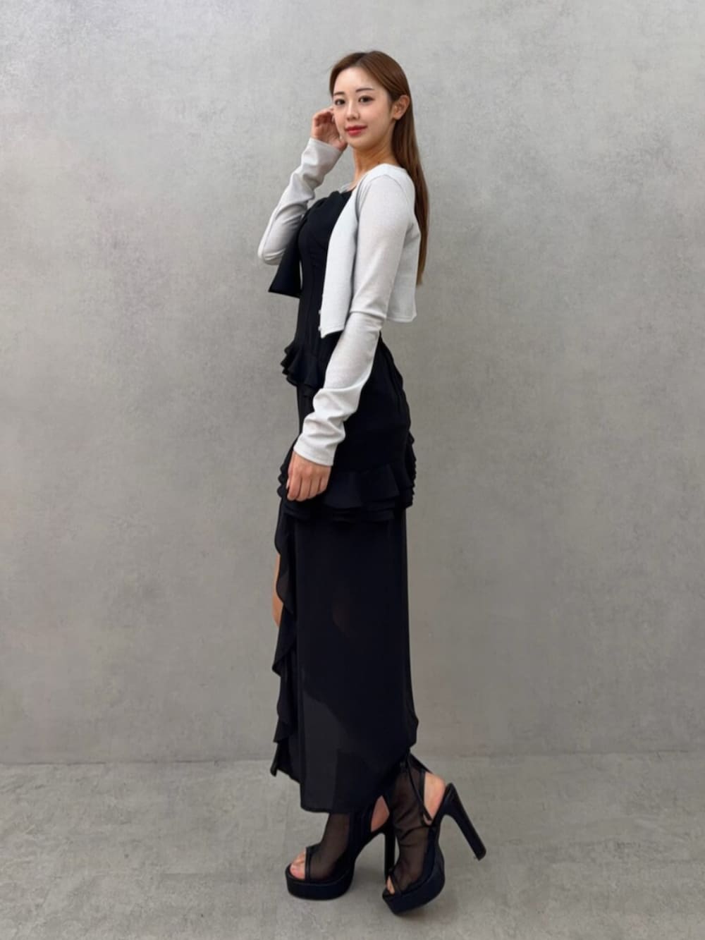 ホワイト系のブーツ、ホワイト系のカーディガン/ボレロ、ブラック系のワンピースを着用したレディースの春コーディネートの5枚目の写真