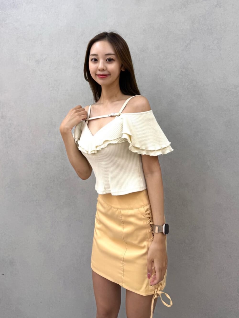 ホワイト系のTシャツ/カットソー、オレンジ系のスカート、ブラック系のブーツを着用したレディースの夏コーディネートの2枚目の写真