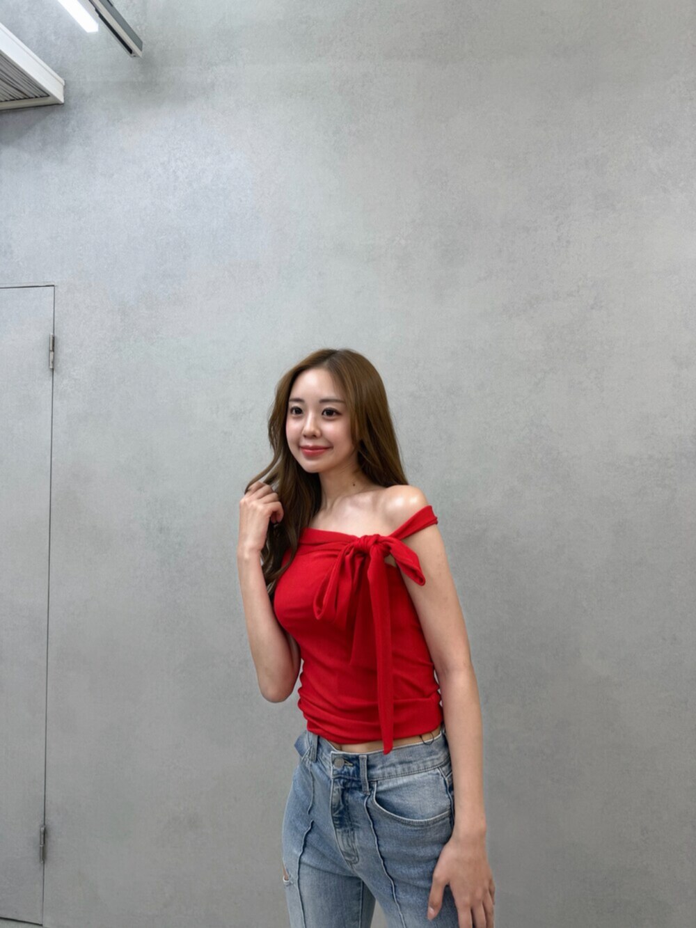 ブラック系のサンダル、レッド系のTシャツ/カットソー、ブルー系のデニムパンツを着用したレディースの春コーディネートの5枚目の写真