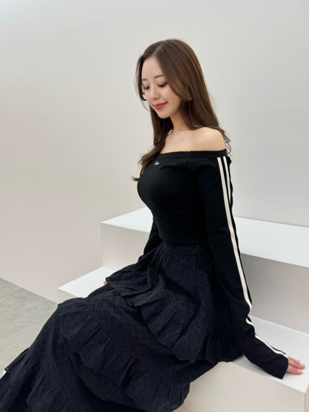 ホワイト系のブーツ、ブラック系のスカート、ブラック系のTシャツ/カットソーを着用したレディースの春コーディネートの5枚目の写真