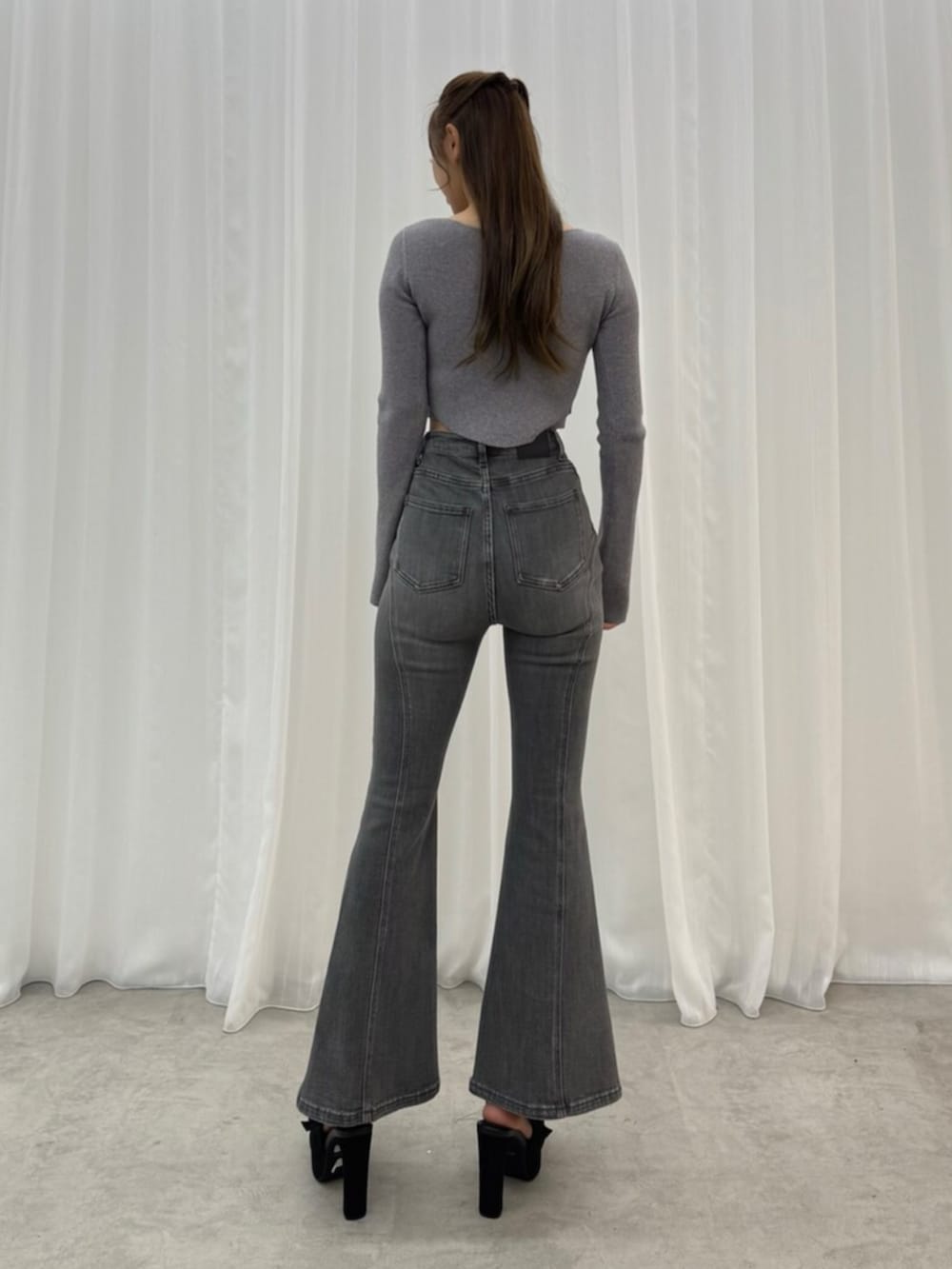 ブラック系のその他シューズ、ブラック系のデニムパンツ、グレー系のニット/セーターを着用したレディースの秋コーディネートの4枚目の写真