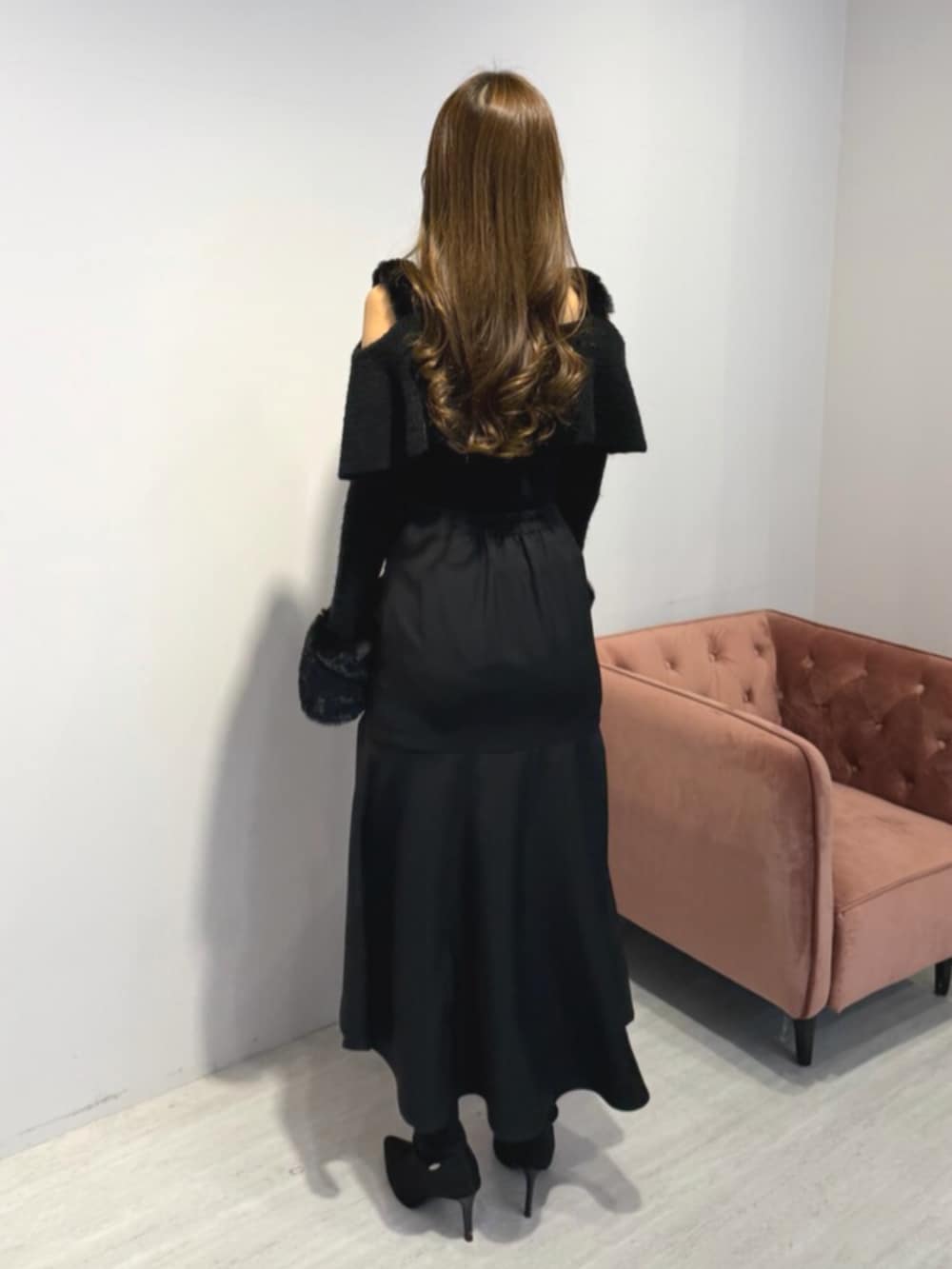 ブラック系のブーツ、ブラック系のニット/セーター、ブラック系のスカートを着用したレディースの冬コーディネートの3枚目の写真