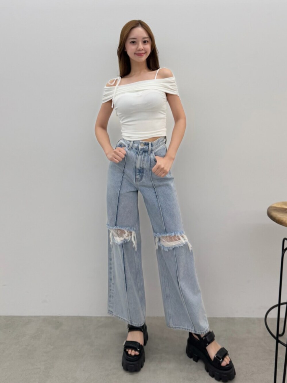 ブルー系のデニムパンツ、ホワイト系のTシャツ/カットソー、ブラック系のサンダルを着用したレディースの春コーディネートの5枚目の写真