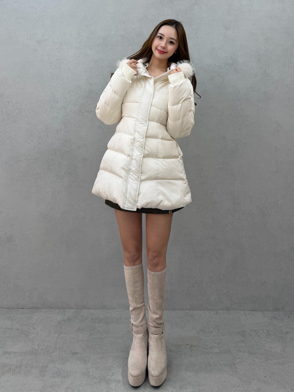 ホワイト系のブーツ、ホワイト系のダウンジャケット/コートを着用したレディースの冬コーディネートの2枚目の写真
