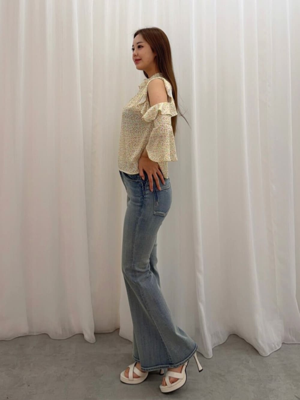 ホワイト系のサンダル、イエロー系のシャツ/ブラウス、ブルー系のデニムパンツを着用したレディースの春コーディネートの3枚目の写真