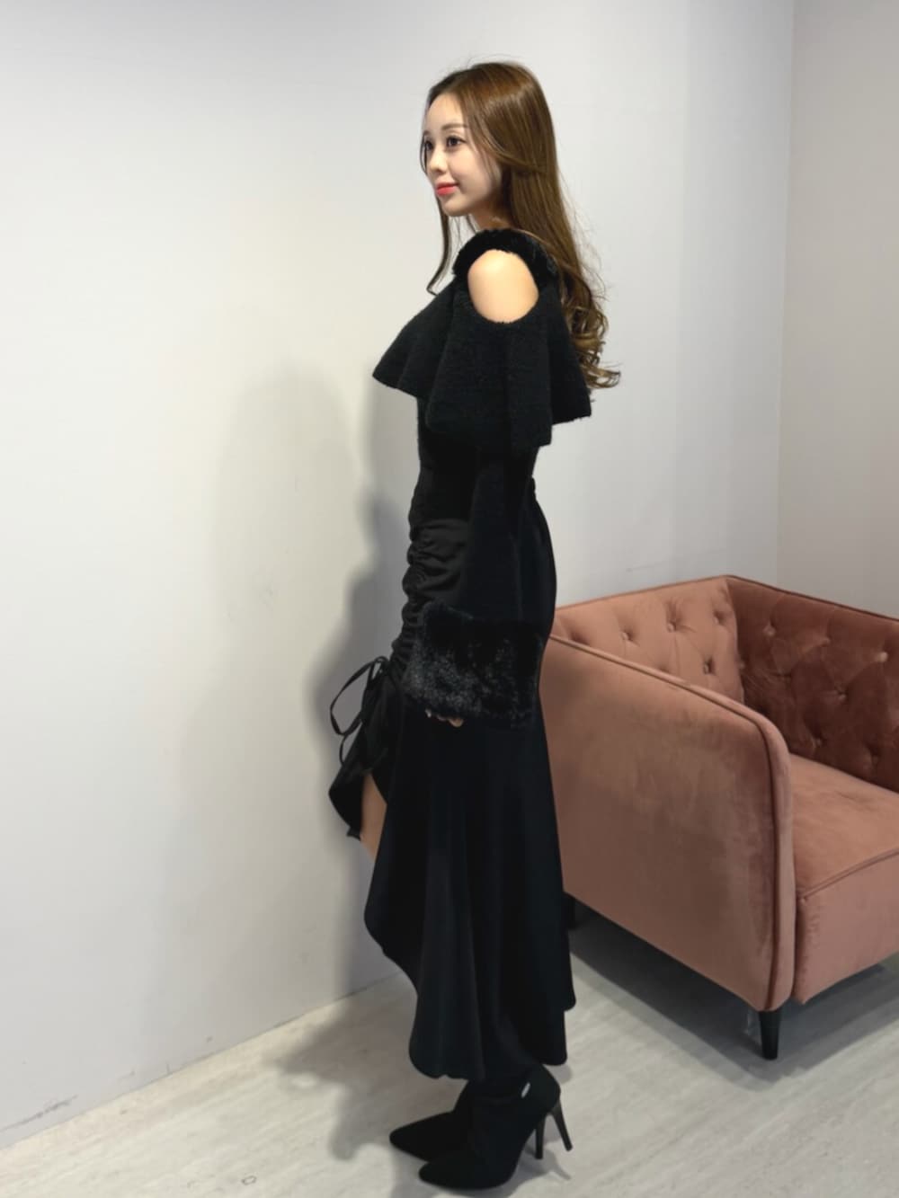 ブラック系のブーツ、ブラック系のニット/セーター、ブラック系のスカートを着用したレディースの冬コーディネートの2枚目の写真