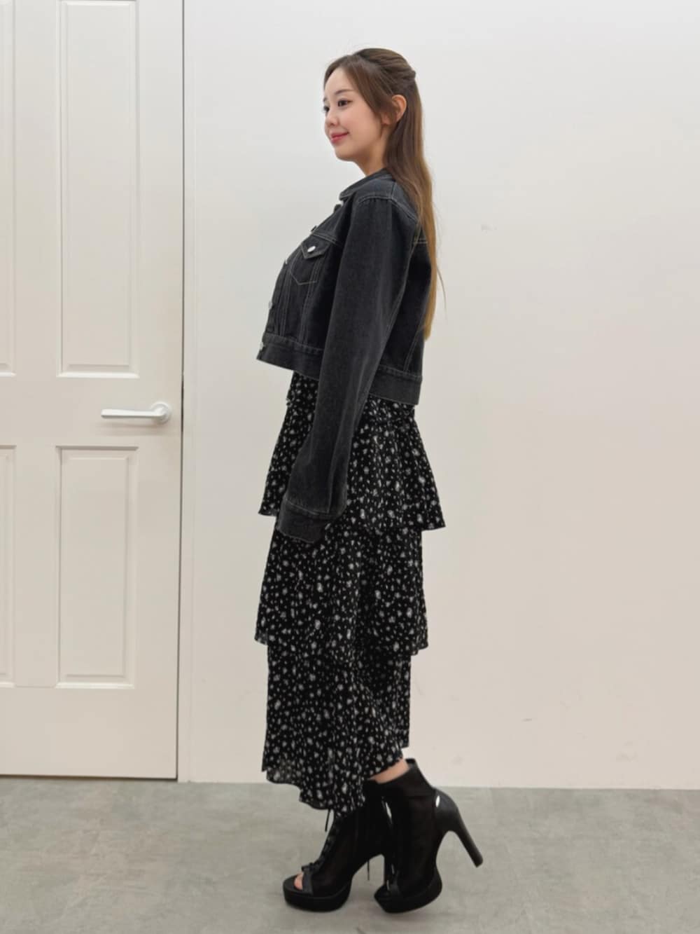 ブラック系のブーツ、ブラック系のワンピース、ブラック系のデニムジャケットを着用したレディースの春コーディネートの2枚目の写真