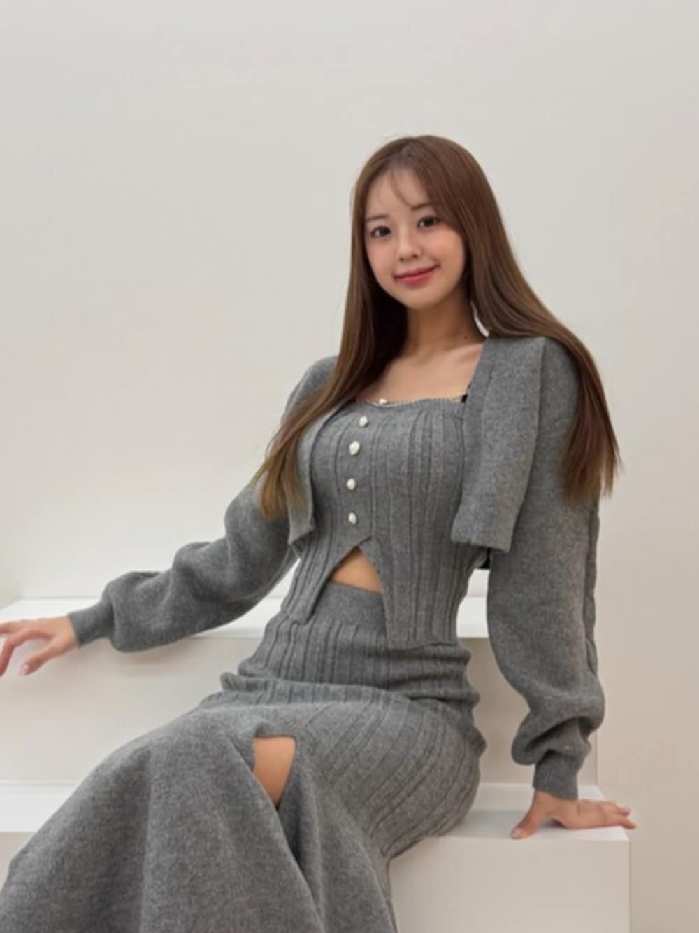 ブラック系のサンダル、グレー系のニット/セーター、グレー系のスカートを着用したレディースの冬コーディネートの3枚目の写真