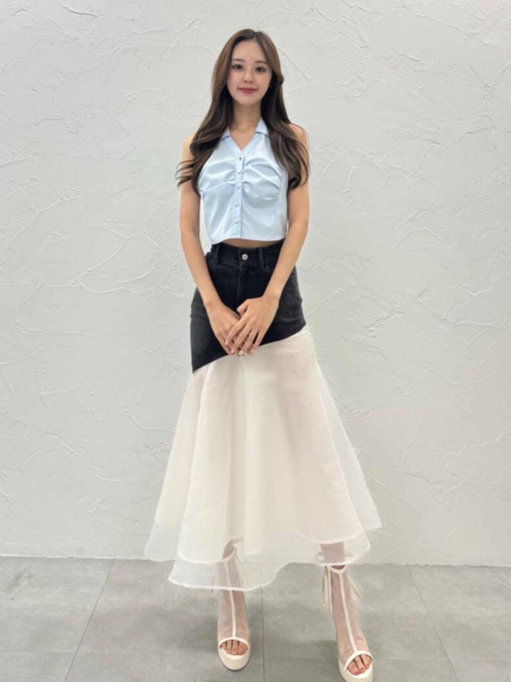 ホワイト系のサンダル、ブルー系のシャツ/ブラウス、ブラック系のデニムスカートを着用したレディースの夏コーディネートの2枚目の写真