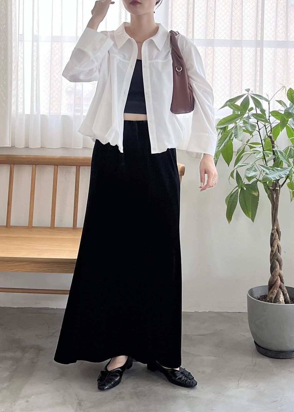 ブラック系のパンプス、ブラウン系のハンドバッグ、ホワイト系のシャツ/ブラウスを着用したレディースの秋コーディネートの2枚目の写真