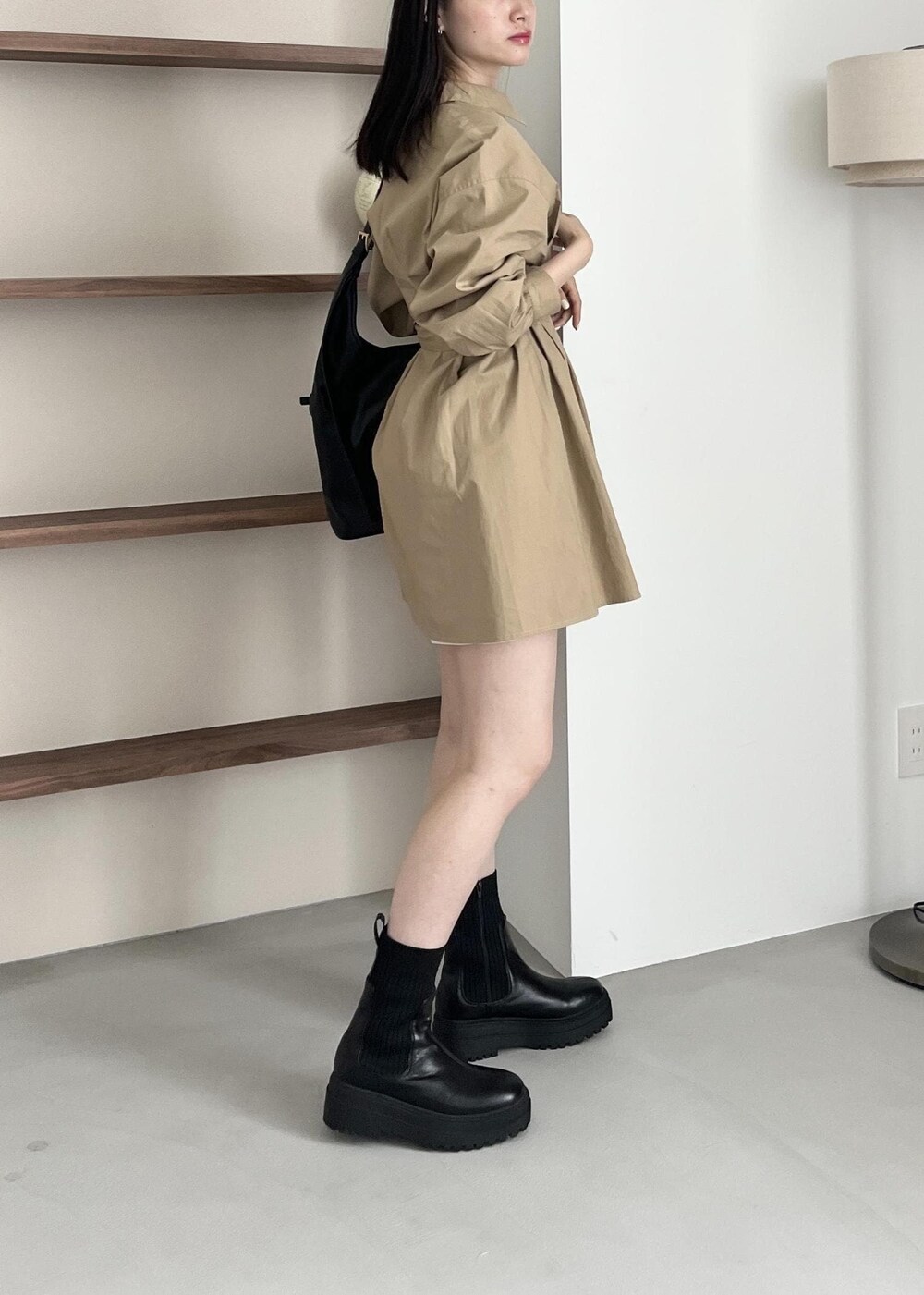 ブラック系のブーツ、ブラック系のショルダーバッグ、ベージュ系のワンピースを着用したレディースの夏コーディネートの3枚目の写真